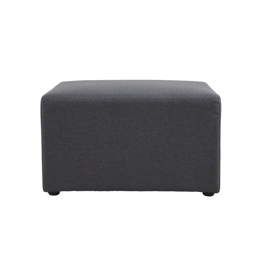 The Konfurb Arco Series by Home Office Space NZ is a square, dark grey fabric ottoman featuring an exceptional minimalist design. It stands on small, barely noticeable legs and has a smooth, cushioned top, making it suitable for use as a footrest or a small coffee table. Ideal for evolving work environments, this ottoman is showcased against a plain white background.
